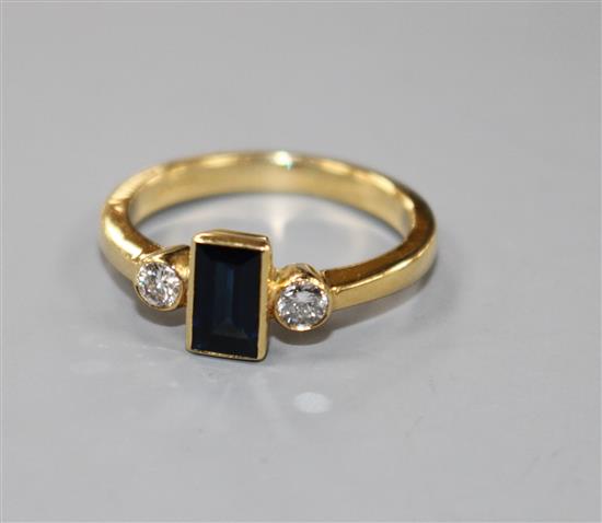 A modern 18ct gold, sapphire and diamond three stone ring, size M.